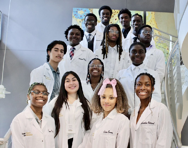 A group of students in white lab coats as part of Georgia Tech’s Project ENGAGES, a high school science education program that works with seven minority-serving public high schools in Atlanta to bring underrepresented groups into STEM fields.