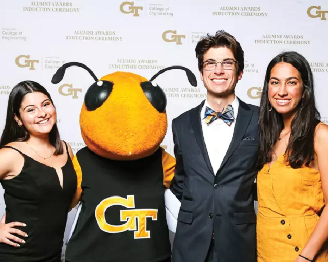 three dean's scholars posing with mascot Buzz