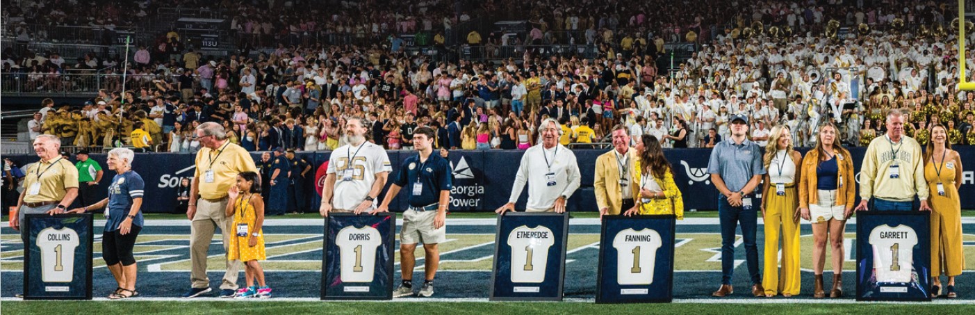 football field with alumni standing