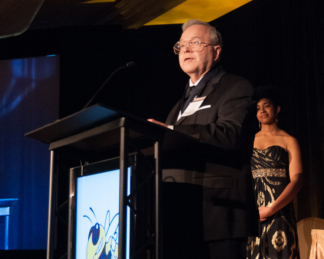 John Durstine presenting at a podium with Buzz on it
