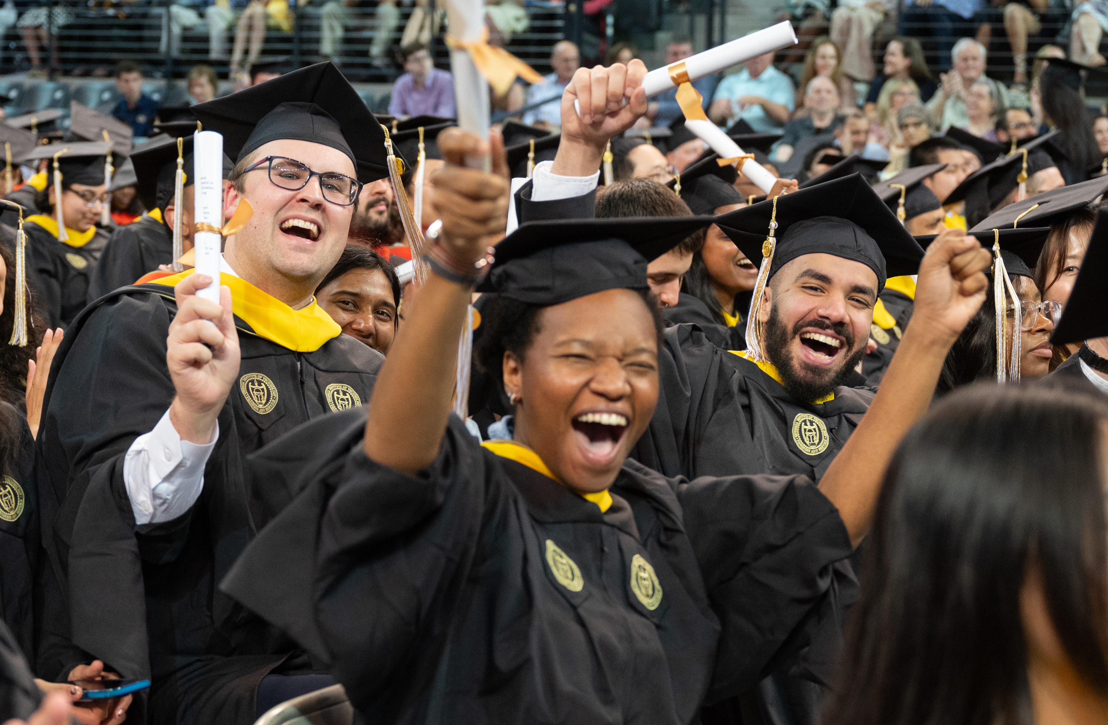 happy graduating students in caps and gowns
