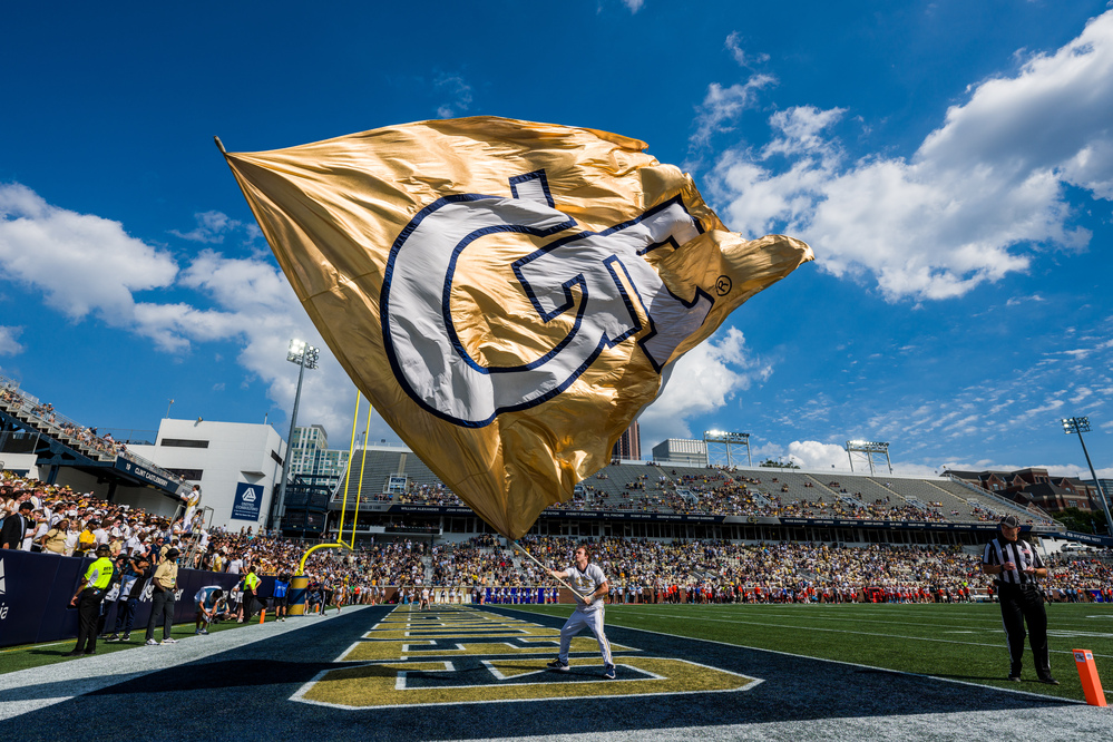 colorguard student with GT flag at football game