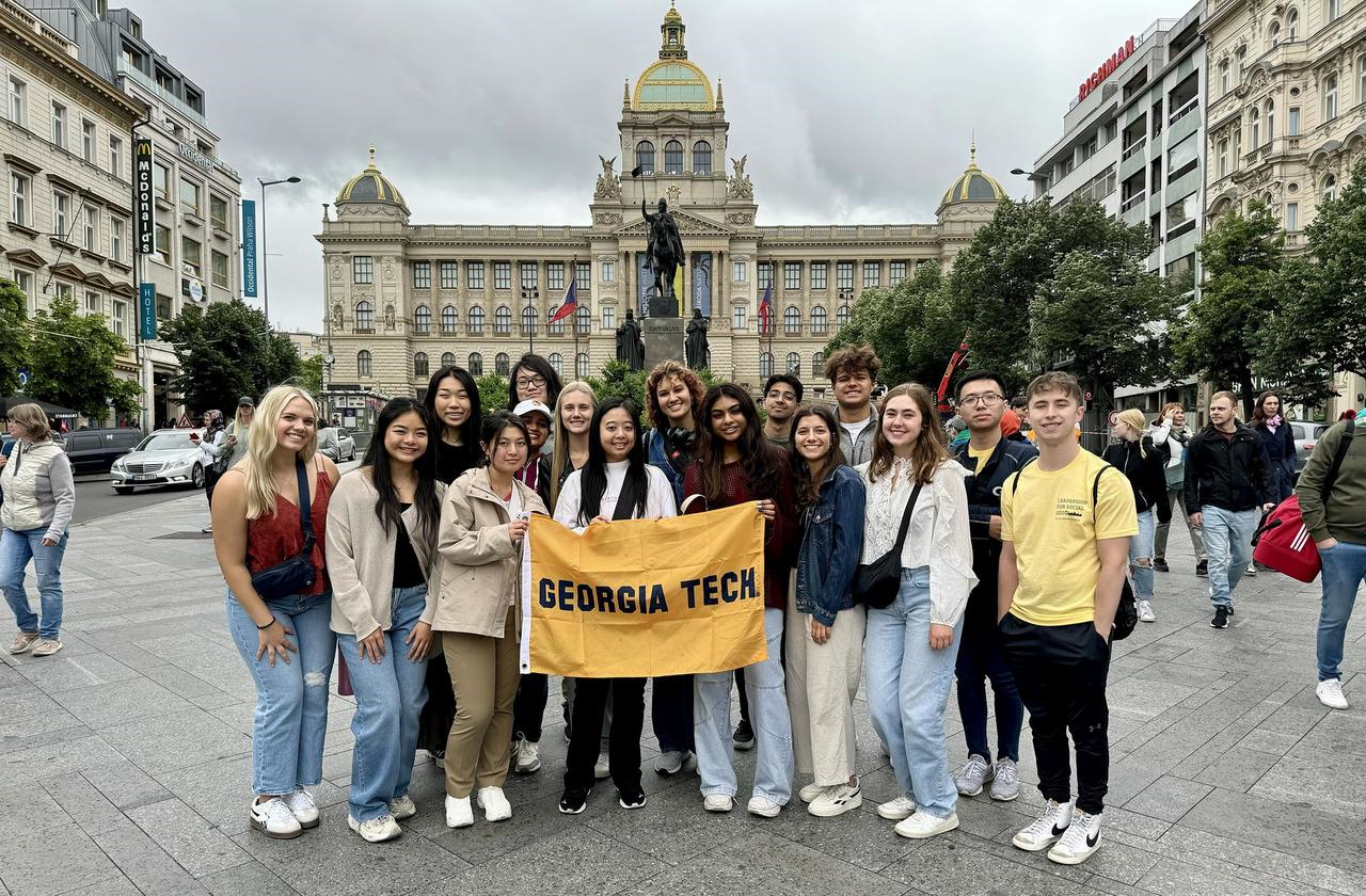 students abroad holding GT flag