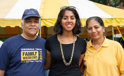 Proud parents standing with their Georgia Tech student at Family Weekend